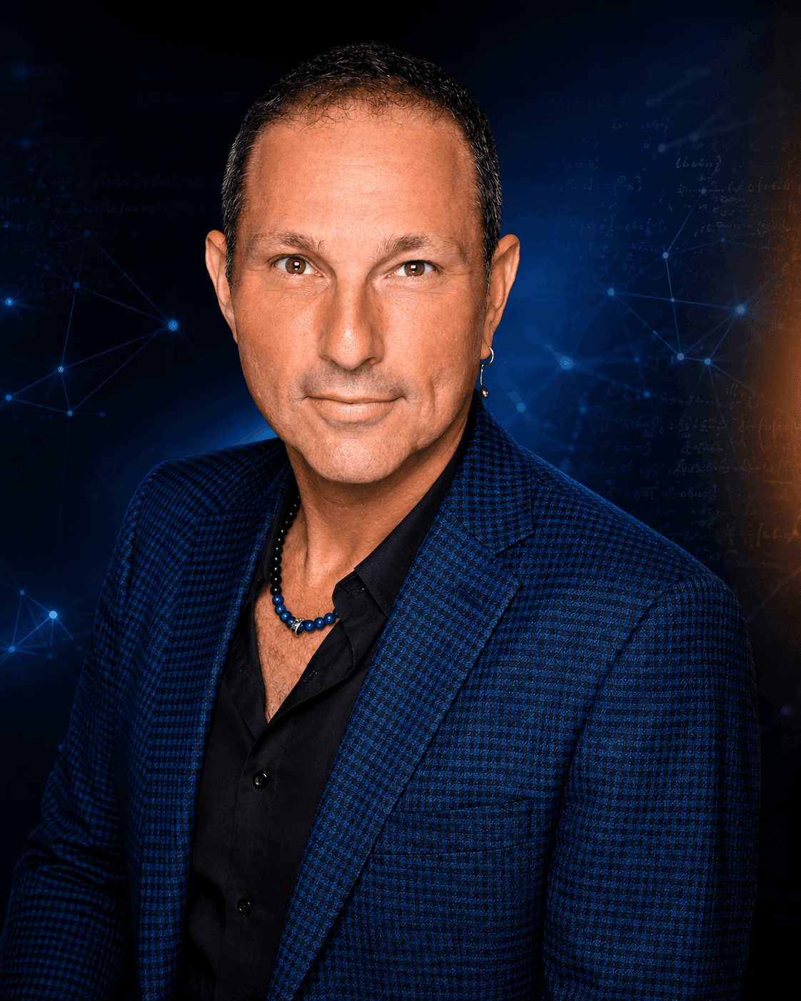Studio portrait of Guy Bavli in a blue jacket against a deep blue network-pattern backdrop